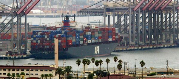 An American President Lines ship loaded with containers is moored next to idle cranes at the Port of Long Beach (File) - Sputnik Moldova-România