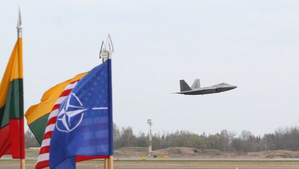 A US Air Force F-22 Raptor fighter aircraft flies at the Air Base of the Lithuanian Armed Forces in Šiauliai, Lithuania, on April 27, 2016 behind flags of US, Lithiania and the NATO - Sputnik Moldova-România
