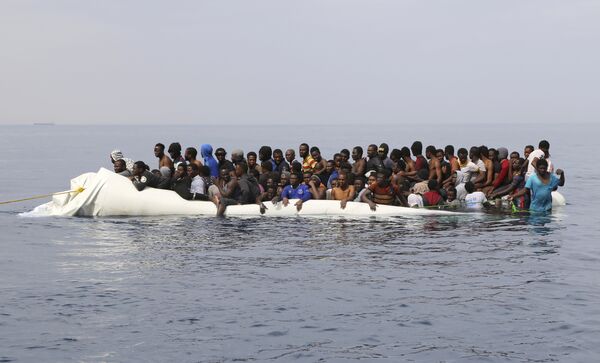 Migranții în așteptarea unui ajutor după ciocnirea a două bărci gonflabile în apropierea țărmului orașului Zawiya din Libia, cu care refugiații încercau să traverseze Marea Mediteraneeană pentru a ajunge în Europa - Sputnik Moldova-România
