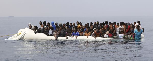 Мигранты ждут спасения после столкновения надувных лодок у ливийского прибрежного города Завия, они пытались пересечь Средиземное море в Европу - Sputnik Moldova-România