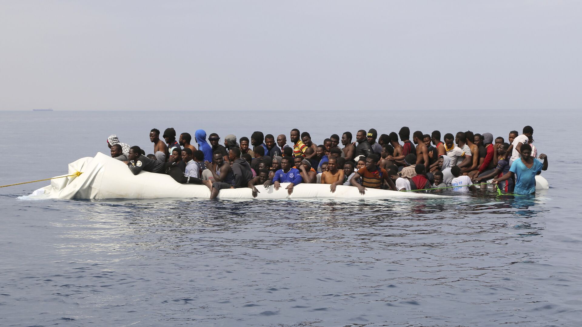 Мигранты ждут спасения после столкновения надувных лодок у ливийского прибрежного города Завия, они пытались пересечь Средиземное море в Европу - Sputnik Молдова, 1920, 05.08.2021