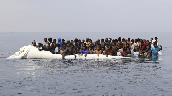 Мигранты ждут спасения после столкновения надувных лодок у ливийского прибрежного города Завия, они пытались пересечь Средиземное море в Европу - Sputnik Молдова