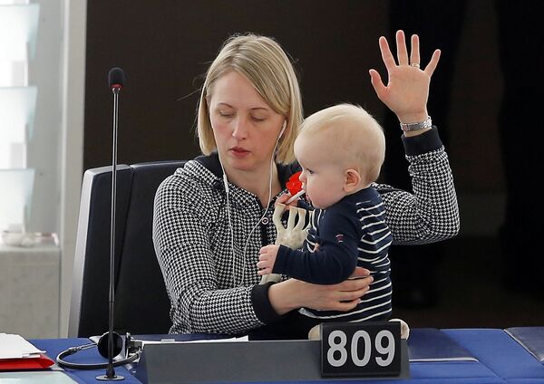 Deputatul european din partea Suediei, Jytte Guteland, își ține în brațe copilul în timp ce votează în Parlamentul European - Sputnik Moldova-România