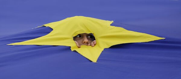 Ребенок смотрит через разрез, сделанный на одной из звезд, которые составляют флаг Европейского Союза, архивное фото.  - Sputnik Молдова