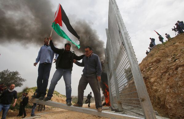 Палестинские демонстранты ломают израильский забор во время протеста в городе Бейт-Джала - Sputnik Молдова