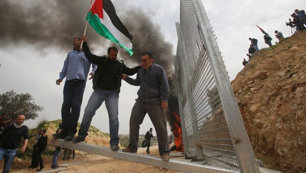 Палестинские демонстранты ломают израильский забор во время протеста в городе Бейт-Джала - Sputnik Moldova-România