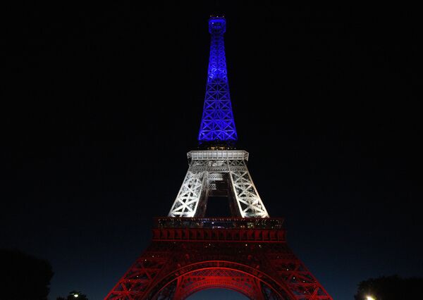 Эйфелева башня в Париже, подсвеченная в цвета французского флага - Sputnik Молдова
