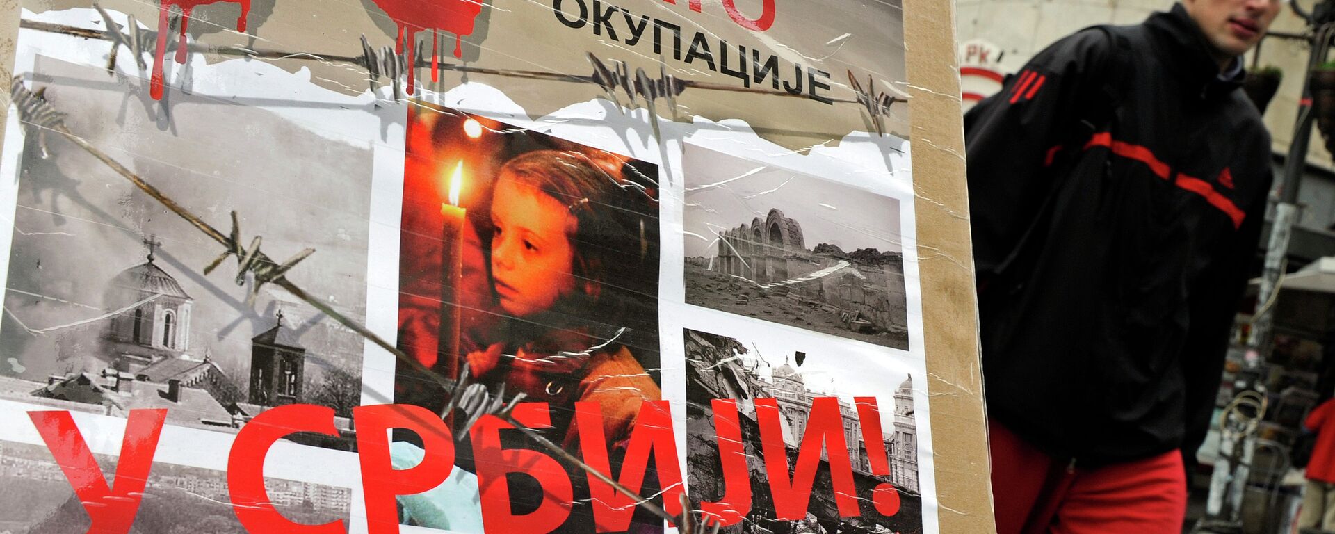 A man walks past a poster with the reading “Ten years of NATO occupation of Serbia”, and displaying images from 1999 NATO air campaign against Serbia and Montenegro, in Belgrade on March 23, 2009.  - Sputnik Moldova-România, 1920, 12.12.2022
