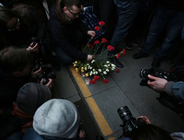Горожане возлагают цветы у входа в вестибюль станции метро Спасская в память о погибших в результате взрыва в метрополитене Санкт-Петербурга - Sputnik Молдова
