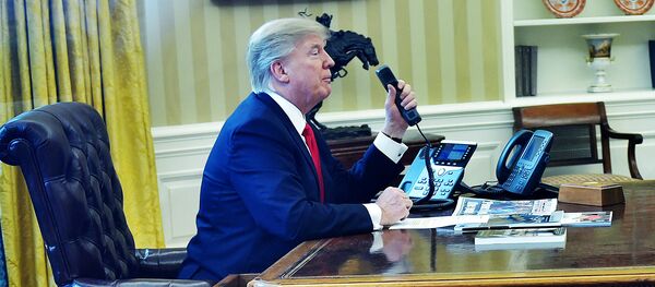 Президент США Дональд Трамп говорит по телефону в овальном кабинете - Sputnik Молдова