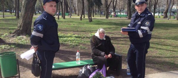 O bătrână care vinde flori în stradă este verificată de doi polițiști - Sputnik Moldova