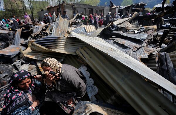 Женщины рыдают на руинах своих домов, разрушенных в результате пожара, в жилом районе города Сринагар, который находится на спорной территории между Индией и Пакистаном - Sputnik Молдова
