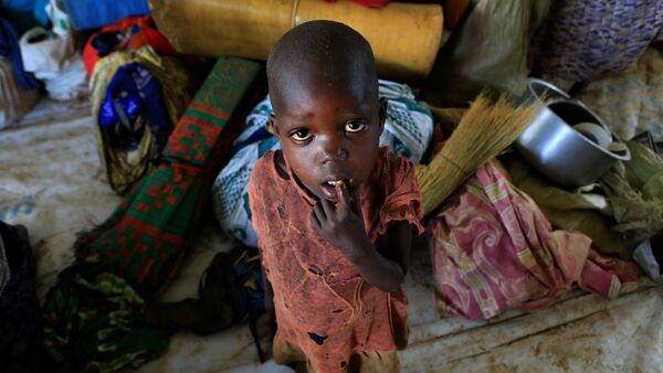 Мальчик-беженец из Южного Судана, который вместе со своей семьей бежал из города Пайок от продолжающихся в их стране боевых действий, разрушений и голода, на территорию Уганды. На фото - мальчик стоит рядом с вещами своей семьи в лагере в Ламво на севере Уганды - Sputnik Moldova
