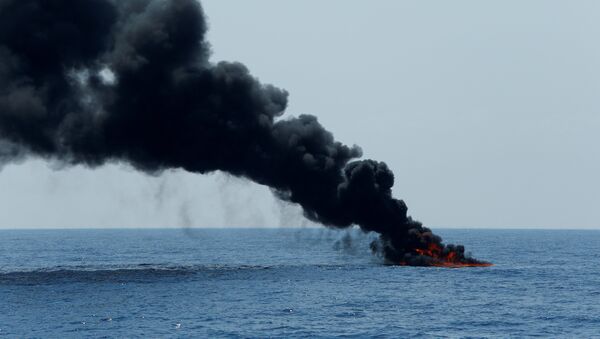 Горящая резиновая лодка тонет в Средиземном море после того, как находившиеся на ее борту мигранты из Ливии были спасены у берегов Мальты местной спасательной службой - Sputnik Молдова