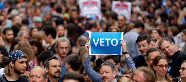 A demonstrator holds up a banner saying Veto during a rally against a new law passed by Hungarian parliament which could force the Soros-founded Central European University out of Hungary, in Budapest, Hungary, April 4, 2017. - Sputnik Moldova-România