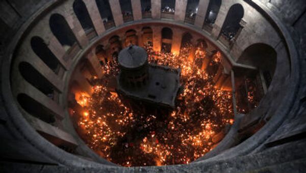 Христианские православные молящиеся зажигают свечи от Благодатного огня в церкви Гроба Господня в Старом городе Иерусалима - Sputnik Молдова