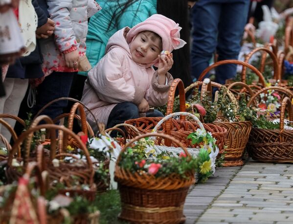 Девочка ждет возле церкви благословения пасхальных куличей и яиц перед богослужением в Пустомытах, Украина - Sputnik Молдова