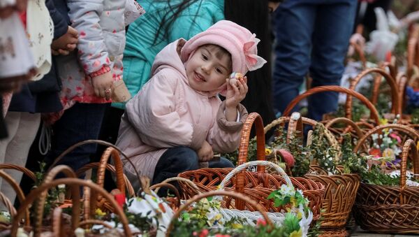Девочка ждет возле церкви благословения пасхальных куличей и яиц перед богослужением в Пустомытах, Украина - Sputnik Молдова