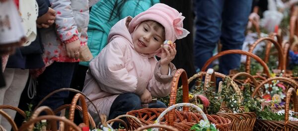 Девочка ждет возле церкви благословения пасхальных куличей и яиц перед богослужением в Пустомытах, Украина - Sputnik Молдова