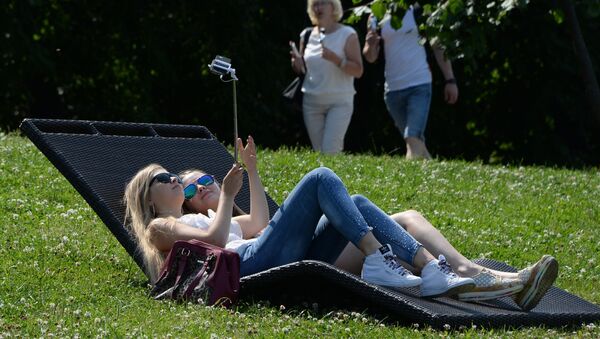 Moscow residents relax on Vorobyovy Hills at the weekend. - Sputnik Молдова