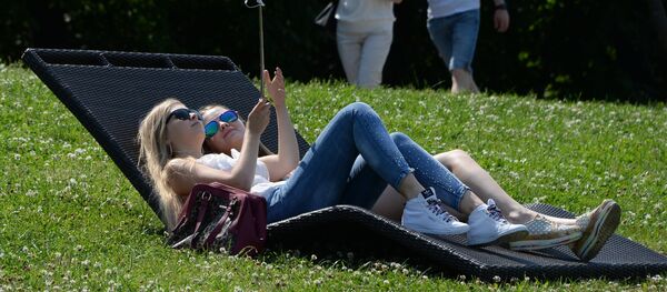 Moscow residents relax on Vorobyovy Hills at the weekend. - Sputnik Молдова