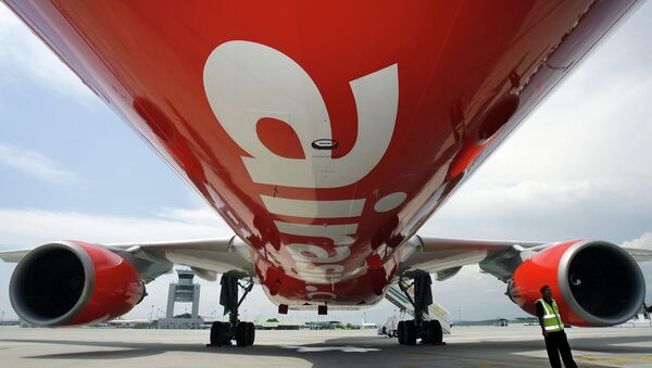 A security officer (R) stands by AirAsia X's first leased Airbus A330 long-haul aircraft as it sits on the tarmac of the Kuala Lumpur International Airport's low-cost carrier terminal in Sepang, 18 September 2007 - Sputnik Moldova-România