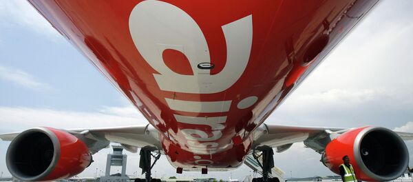 A security officer (R) stands by AirAsia X's first leased Airbus A330 long-haul aircraft as it sits on the tarmac of the Kuala Lumpur International Airport's low-cost carrier terminal in Sepang, 18 September 2007 - Sputnik Moldova-România
