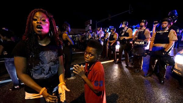 Amarion Allen, 11-years-old (C), and his mother Amima stand in front of a police line shortly before shots were fired in a police-officer involved shooting in Ferguson, Missouri August 9, 2015. - Sputnik Moldova