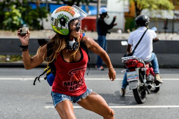 Девушка с камнем во время антиправительственных протестов в День труда в Каракасе, Венесуэла - Sputnik Молдова