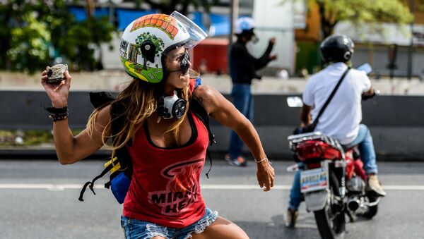 Девушка с камнем во время антиправительственных протестов в День труда в Каракасе, Венесуэла - Sputnik Молдова