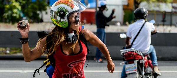 Девушка с камнем во время антиправительственных протестов в День труда в Каракасе, Венесуэла - Sputnik Молдова