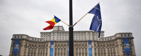 File photo of the Romanian and the NATO flag flutter in the wind in front of the Parliament Palace, the second largest building in the world after the Pentagon, in Bucharest on April 1, 2008 on the eve of the start of the NATO summit taking place form April 2 to 4 - Sputnik Moldova