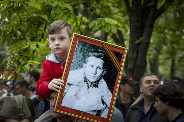 Ребенок держит фотопортрет своего предка-участника Великой Отечественной войны - Sputnik Молдова