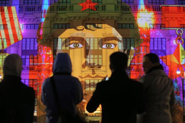 Зрители во время светового мультимедийного шоу О Победе, демонстрируемого на фасаде здания на Манежной площади в Москве - Sputnik Молдова