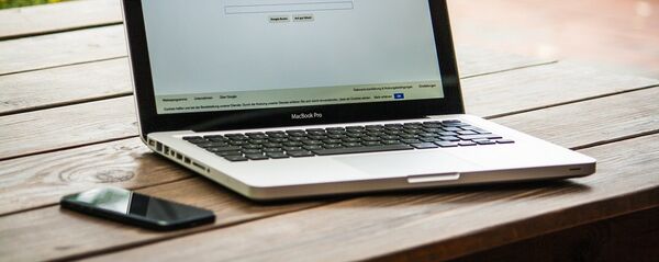 Ноутбук на столе с интернет-страницей Google - Sputnik Молдова