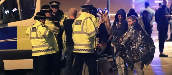 Emergency services personnel speak to people outside Manchester Arena after reports of an explosion at the venue during an Ariana Grande concert in Manchester, England, Monday, May 22, 2017. - Sputnik Moldova