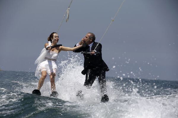 Ливанец Томми целует руку своей невесты Надин, во время катания на водных лыжах в водах залива Джуния к северу от Бейрута - Sputnik Молдова