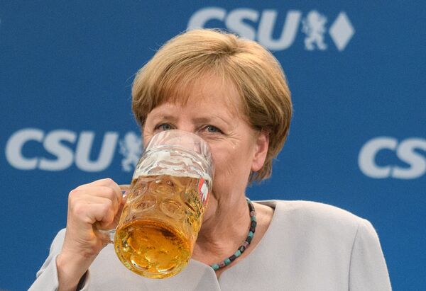 Канцлер Германии Ангела Меркель с бокалом пива после выступления в Мюнхене, Южная Германия - Sputnik Молдова