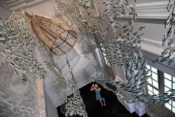 Женщина фотографирует инсталляцию о морской жизни, созданную из брошенных рыболовных сетей группой художников из Австралии - Sputnik Молдова