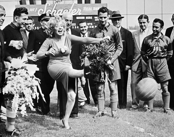 Американская актриса Мэрилин Монро бьет по мячу перед началом матча футбольного израильского клуба Хапоэль против команды всех звезд сборной США, Нью-Йорк, 16 мая 1957 года - Sputnik Молдова