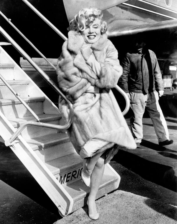 Американская актриса Мэрилин Монро позирует фотографам в аэропорту Ла Гардиа в 1959 году, прежде чем лететь в Чикаго на презентацию фильма В джазе только девушки - Sputnik Молдова