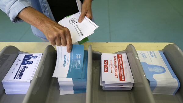 Voter picks up ballots at a polling station before voting for the first round of parliamentary elections in Marseille, southern France, Sunday, June 11, 2017 - Sputnik Moldova-România