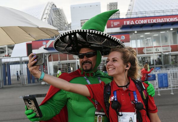 Болельщик сборной Мексики фотографируется с волонтёром - Sputnik Молдова