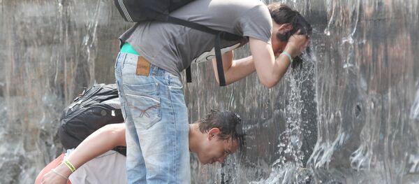 People cool down by placing their heads under running water from a fountain in Moscow. - Sputnik Moldova