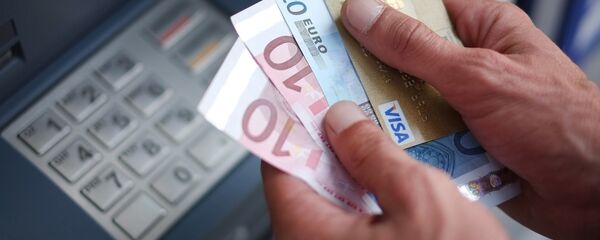 A man takes out Euro banknotes from an automated teller machine (ATM) - Sputnik Moldova-România