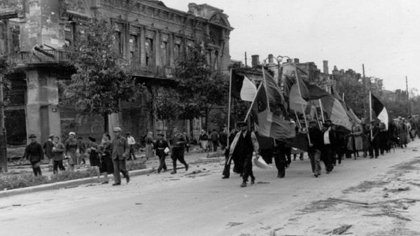 Шествие с триколорами, в задних рядах есть даже плакат со свастикой. Колонна движется по нынешнему бульвару Штефан чел Маре от нынешней улицы Влайку Пыркэлаб в сторону улицы Пушкина. Видны руины бывшей гостиницы Бристоль. - Sputnik Молдова
