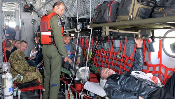 Medical personnel from the Romanian military take wounded Ukrainian soldiers on board a Romanian medical military plane at Kiev's Boryspil International Airport on April 29, 2015 - Sputnik Moldova-România