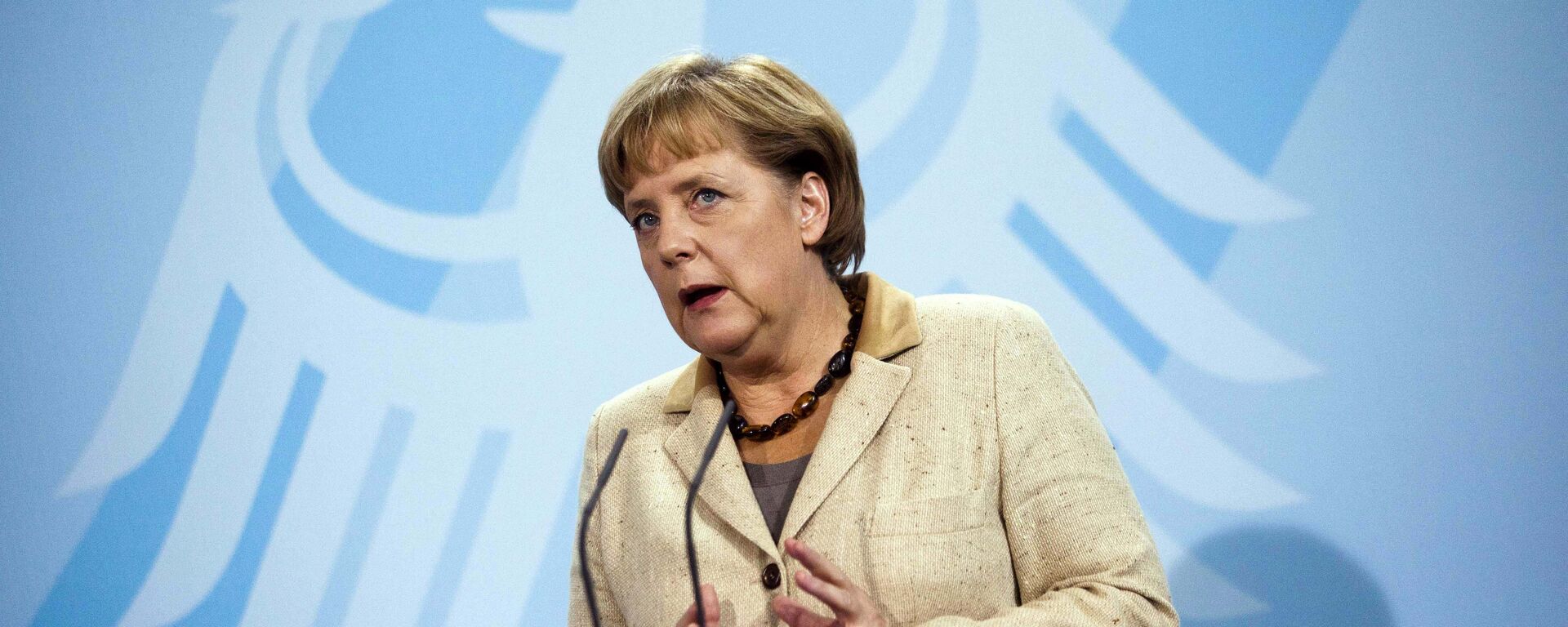 German Chancellor Angela Merkel  in front of Germany's heraldic eagle - Sputnik Moldova, 1920, 07.10.2025