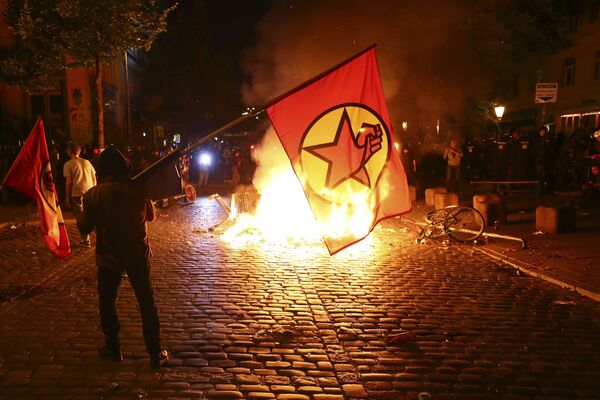 Один из протестующих у горящей баррикады - так ночью в Гамбурге проходили акции протеста против саммита G20 - Sputnik Молдова
