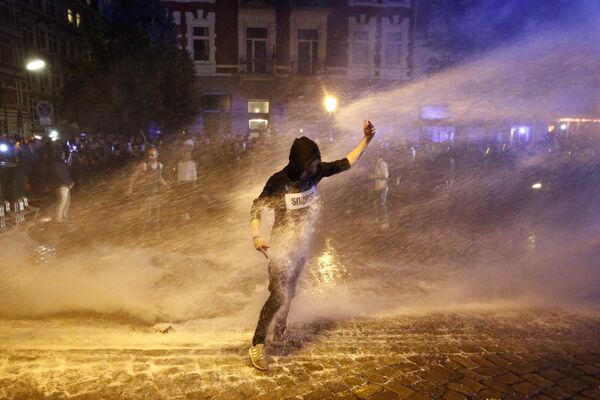 Один из демонстрантов, протестующих против саммита G20 в Гамбурге, пытается устоять на ногах во время разгона акции с применением водометов - Sputnik Молдова